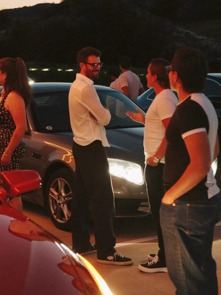 Car enthusiasts gathered at an evening meet