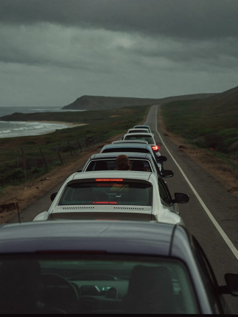 A convoy of cars on a coastal road