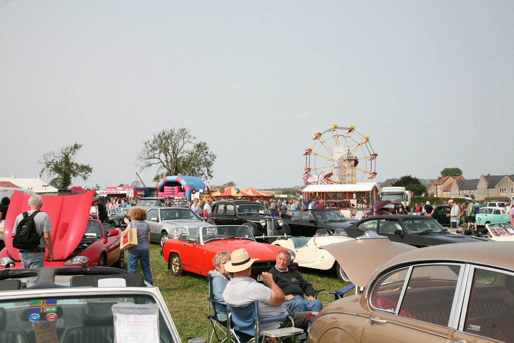 Classic cars and a fairground at a weekend car show