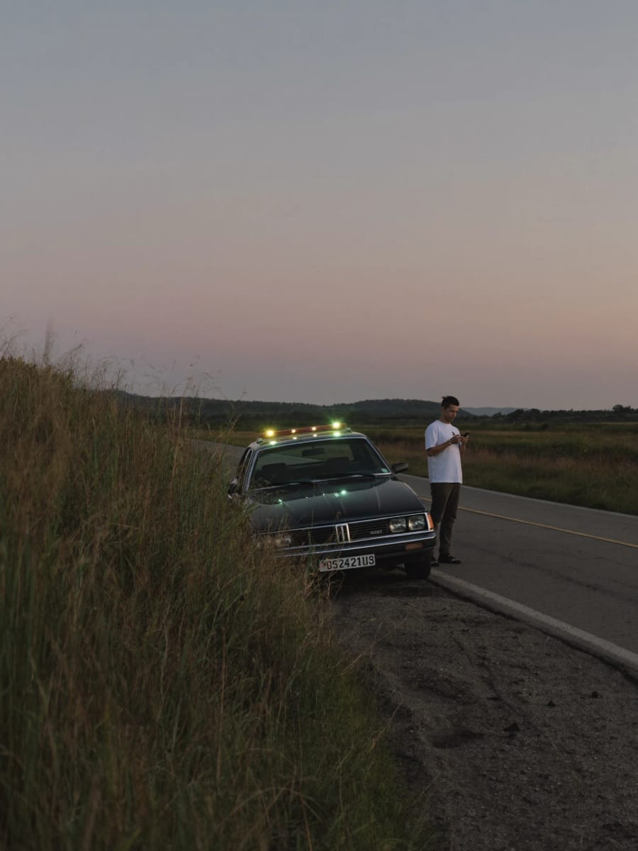 A car pulled over at dusk with hazard lights
